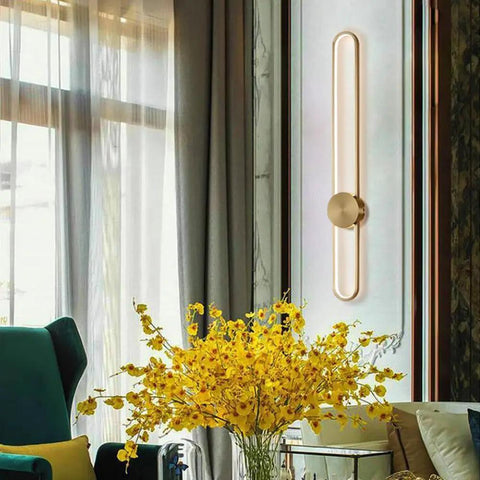 Slick Modern Wall Sconce Light Fixture Offering Three Color Temperatures And Built In Led Bulbs mounted beside a yellow flower arrangement.