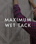 Man applying wallpaper with clear strippable wallpaper adhesive for easy installations, emphasizing maximum wet tack.