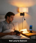 Hardwired Black Wall Sconce With USB Port and Reading Lamp in bedroom setting, linen shade, bedside table, man reading