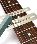 Guitar Luthier Tool Kit with fingerboard guards and grinding stone on guitar fretboard for precise fret work setup and maintenance.