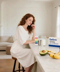 Woman using pH Test Strips Universal Range 4.5 To 9.0 with fruits on kitchen counter