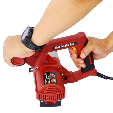 Close-up of a Heavy Duty Corded Toe Kick Circular Saw in a person's grip, showcasing ergonomic design for precision cabinet cuts.