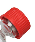 Close-up of red cap on evaporating glass bottle for watch repair precise lubricant application and diffusion prevention.