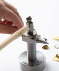 Jewelry Hammer With Solid Wood Handle And Iron Head For Precise Metalworking in use with metal craft shapes on a workbench.