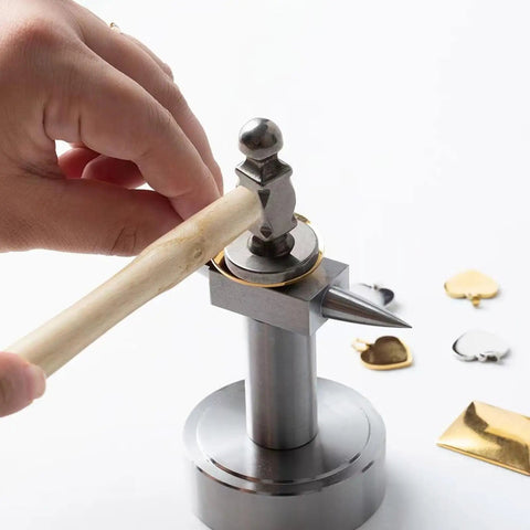 Jewelry Hammer With Solid Wood Handle And Iron Head For Precise Metalworking in use with metal craft shapes on a workbench.