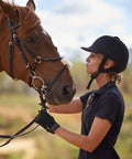 Woman wearing Women Equestrian Riding Gloves Super Lightweight So Comfy With Durable Reinforced Stitching Double Layer Forefinger Grippy Breathable Palms Perfect For All Day Horse Riding And Training, holding a horse's reins outdoors