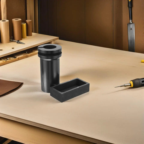 Heavy Lifter Graphite Crucible And Metal Smelting Mold Set With Integrated Oil Traps on a workbench for metal casting and refining.