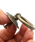 Close-up of Vintage Antique Brass Ring Pull Handle showing round disk shield, thick ring, and zinc alloy material in hand.