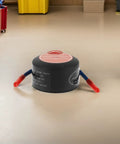 No Brainer Car Safety Upgrade Automatic Aerosol Fire Extinguisher With Rapid Heat Activation and Peel Stick Adhesive Mount for Engine Bays Garages and Office Spaces on a floor.
