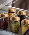 Modern Round Kitchen Countertop Storage Canisters Sleek Airtight Tea Jars with gold lids holding beans and spices in a drawer.