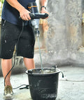 Heavy Duty 12 Amp Concrete And Mortar Mixer With Soft Start in use, mixing concrete with large spiral paddle in renovation setting.
