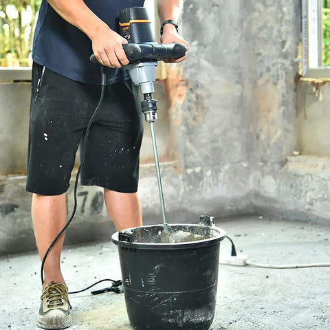 Heavy Duty 12 Amp Concrete And Mortar Mixer With Soft Start in use, mixing concrete with large spiral paddle in renovation setting.