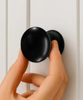 Hand installing Matte Black Large Bifold Closet Door Knobs Four Pack With Renovation Ready Wide Base Zinc Round Kitchen Wardrobe