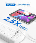 12-Outlet Surge Protector Power Strip With 4 USB Ports, 6-Foot Cord, charging tablet and phone next to strip, 2.5X faster
