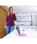 Woman using Cordless Handheld Vacuum For Home And Car Cleaning, Lightweight Grab-And-Go Dustbuster on kitchen counter spill