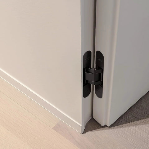 Invisible 5.5 Inch 3 Way Adjustable Concealed Door Hinges Matte Black Zinc Alloy 180 Degree Swing Hidden Butt Hinge For Doors 38mm To 60mm Thick 66 Lb Per Hinge No Fuss Vertical Horizontal And Depth Adjustments No Visible Hardware installed on white door corner.