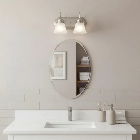Brushed Nickel 2 Light Vanity Bath Light With Satin Etched Glass Shades above oval mirror in modern bathroom setting, 12.25 Inch Wide, 8 Inch High