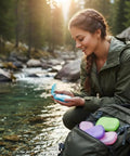 Woman outdoors using Grab and Go Disposable Soap Sheets Set, 5 Boxes of Fragrant Paper Soap for quick cleanups while camping by a stream.