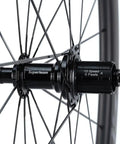 Close-up of 50/25mm UD Matte Finish Carbon Wheelset hub for 700c Tubeless Ready Black Road Bike with V Brake Compatibility Shimano