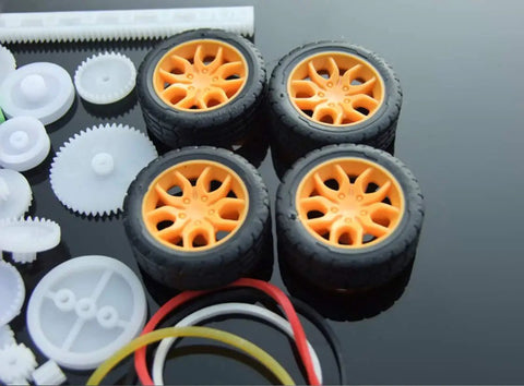 Close-up of orange wheels and plastic gears from 78 Piece Plastic Gear Kit For Motors And Robots With Single And Double Reduction Gears Bevel Gears Racks Axles Tires And Bushings For DIY Cars Robots And Custom Gearbox Projects.
