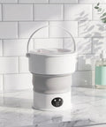 Sweet Compact Folding Mini Washing Machine Portable Travel Washer For Socks Underwear And Delicates Quick Rinse Auto Drain Straight Up Compact Design For Dorms on a marble counter.