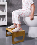 Child sitting on toilet using Foldable Bamboo Squatting Toilet Stool With Non Slip Mat For Adults And Kids, 8.1 Inch Height, No Installation.