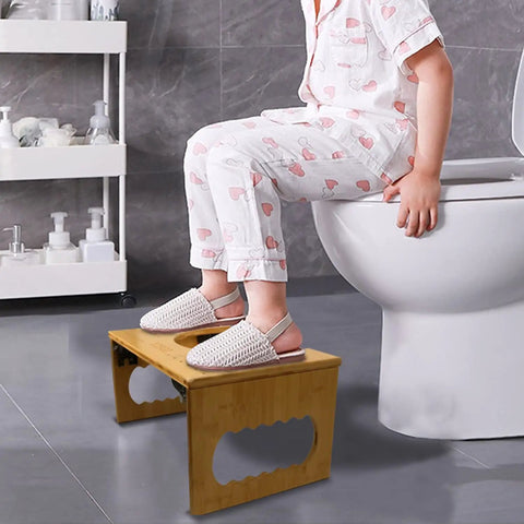 Child sitting on toilet using Foldable Bamboo Squatting Toilet Stool With Non Slip Mat For Adults And Kids, 8.1 Inch Height, No Installation.