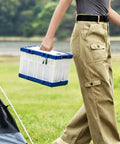 Person carrying a Breathable Lockable Travel Cage Carrier For Birds Pigeons Parrots And Parakeets, blue-white plastic design.
