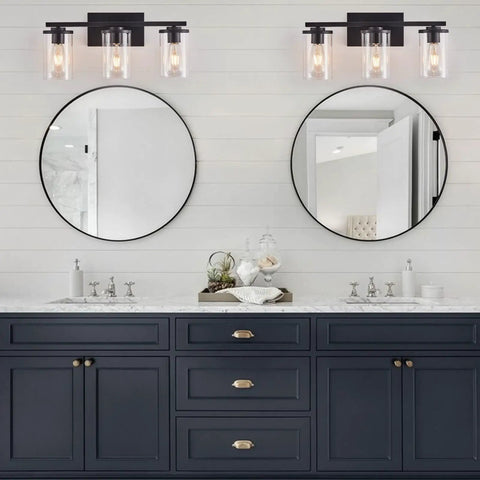 Three Light Vanity Light Fixture With Clear Glass Shades Slick Matte Black Wall Sconce Above Double Bathroom Mirror