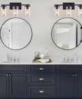 Matte Black Four Light Vanity Fixture With Clear Glass Shades in modern bathroom with round mirrors and navy cabinets