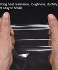 Hands holding clear Polyolefin Shrink Wrap Bags 10 X 7 Inch Clear Heat Seal Film 100 Pack showcasing durability.