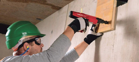 Worker using a powder actuated fastener cartridge tool for concrete and steel, .27 caliber, short 6.8/11 mm, yellow medium duty.