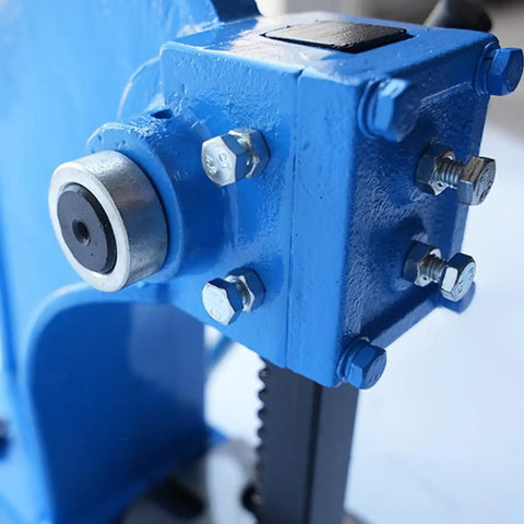 Close-up of Solid Cast Iron Manual Arbor Press 2 Ton showing blue frame, bolts, and reversing plunger mechanism.