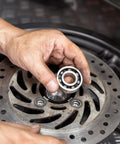 6701-2RS deep groove ball bearing (12x18x4 mm), chrome steel, double sealed, held near a perforated brake rotor
