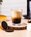 Coffee made with Upgrade Your Coffee Game With This Reusable Capsule Set For VertuoLine Machines next to refillable pod on table