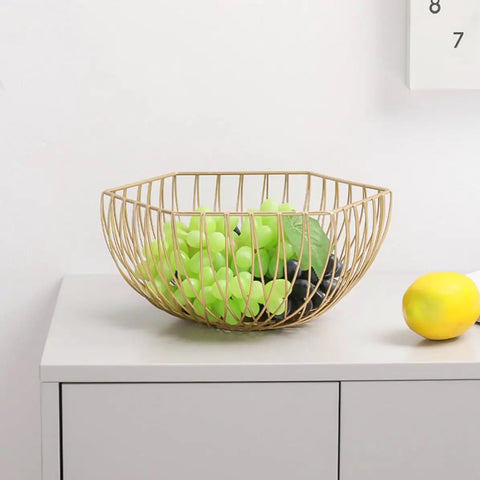 Golden Iron Fruit Basket For Fruits And Vegetables With Draining Water Feature And Geometric Wire Design Stackable Storage Organizer For Kitchen And Bathroom Use holding green grapes on kitchen counter