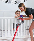 Woman using a vacuum near a crib, demonstrating Upgraded Version 3 Pack Pro Grade HEPA Replacement V10 Filters Compatible With V10 Cyclone Series.