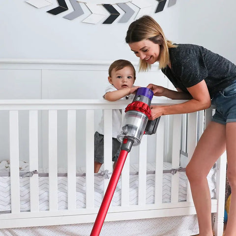 Woman using a vacuum near a crib, demonstrating Upgraded Version 3 Pack Pro Grade HEPA Replacement V10 Filters Compatible With V10 Cyclone Series.