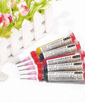 Five color UV curable solder kit with needles and plastic tube pistons next to a flower pot for PCB protection solder paste flux
