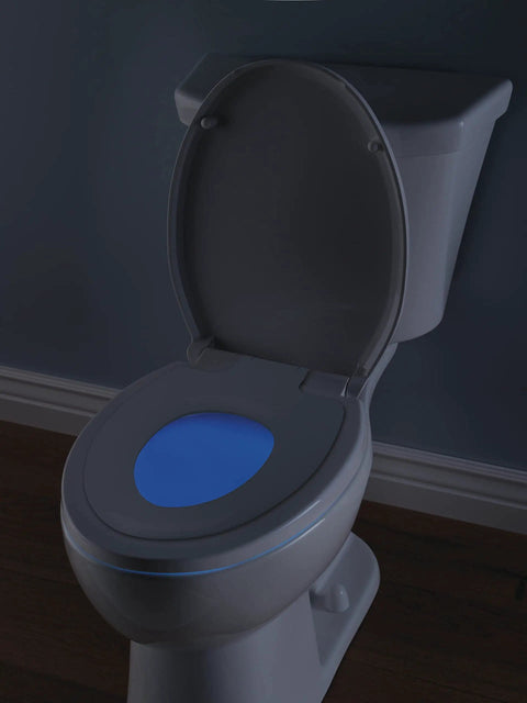Sanborne Slow Close Round Toilet Seat With Built In Child Seat And Nightlight Soft Close Round Toilet Seat For Potty Training White 823902 N WH With A Removable Child Training Seat And Night Light Glow For Late Night Visits showing glowing nightlight in a dark bathroom.