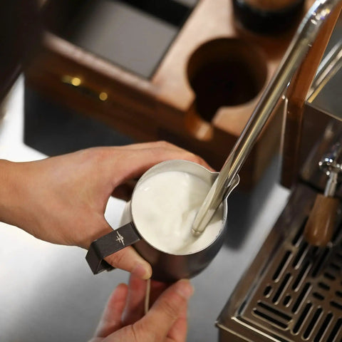 12 Oz Stainless Steel Milk Frothing Pitcher For Espresso And Latte Art Black Round Spout Milk Jug being used on espresso machine.