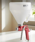 Professional Air Texture Spray Gun With 1.45 Gallon Hopper And Swappable Nozzles for drywall texturing, featuring a red handle and white hopper.