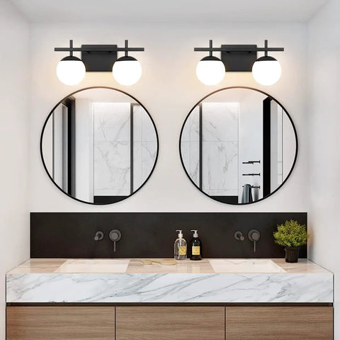Two Light Black Vanity Light Fixtures with White Frosted Glass Globes in modern bathroom above dual mirrors.
