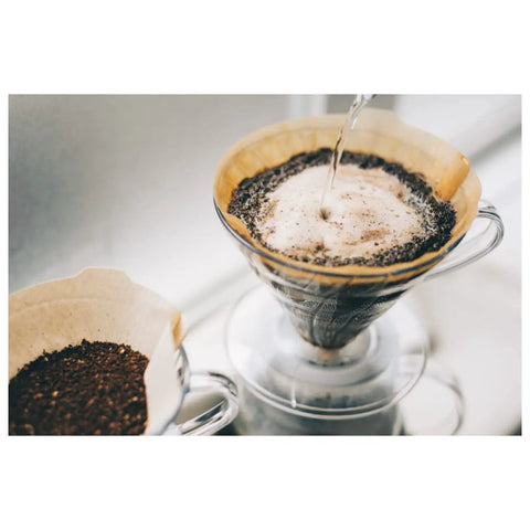 V60 Size 02 Paper Coffee Filters Natural Unbleached 40 Count For Pour Over Drippers Cone Style Fits 1 To 4 Cups Ideal For Clean Smooth Brew And Mess Free Pour Overs in use on a glass pour over dripper with coffee grounds.