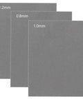 Gasket material sheets set (front view), three gray sheets with thicknesses 0.8mm, 1.0mm, and 1.2mm.