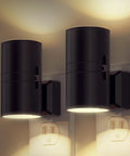 Two black cylindrical plug-in LED night lights mounted on wall, dusk-to-dawn sensor, 3000K soft white, dimmable.
