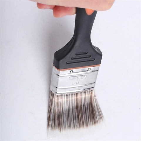 Hand holding versatile paint brush set for DIY projects and home improvement includes 2 inch wide brushes for stains varnishes