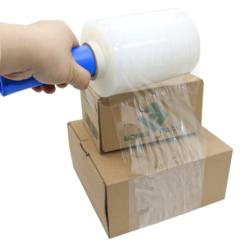 Hand using Industrial Mini Stretch Wrap Film Replacement 5 Inch By 1000 Foot Roll 80 Gauge Heavy Duty Grip Ready Self Adhering Packing Wrap