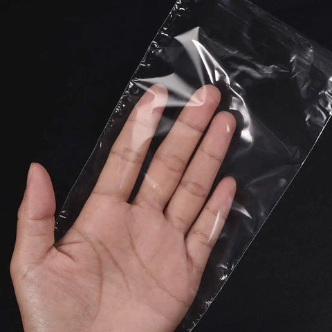 Polyolefin Shrink Wrap Bags 10 X 7 Inch Clear Heat Seal Film 100 Pack held in a hand, showcasing flexibility and clarity.