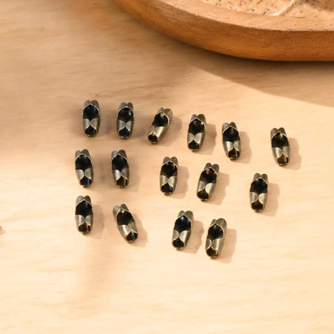 80 Pack Bronze Ball Chain Connectors in 3mm and 3.2mm Sizes with Bronze, Black, and Silver Clips, Durable Metal Fan Pull Chain Connectors for Jewelry, DIY, Crafts on wood surface